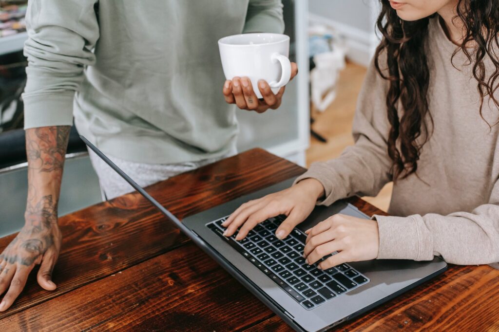woman in brown long sleeve shirt using macbook pro